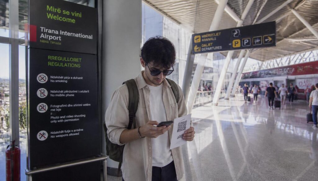 Pessoa escaneando um QR Code digital na tela de um notebook usando o smartphone para ativar o eSIM para Albânia.