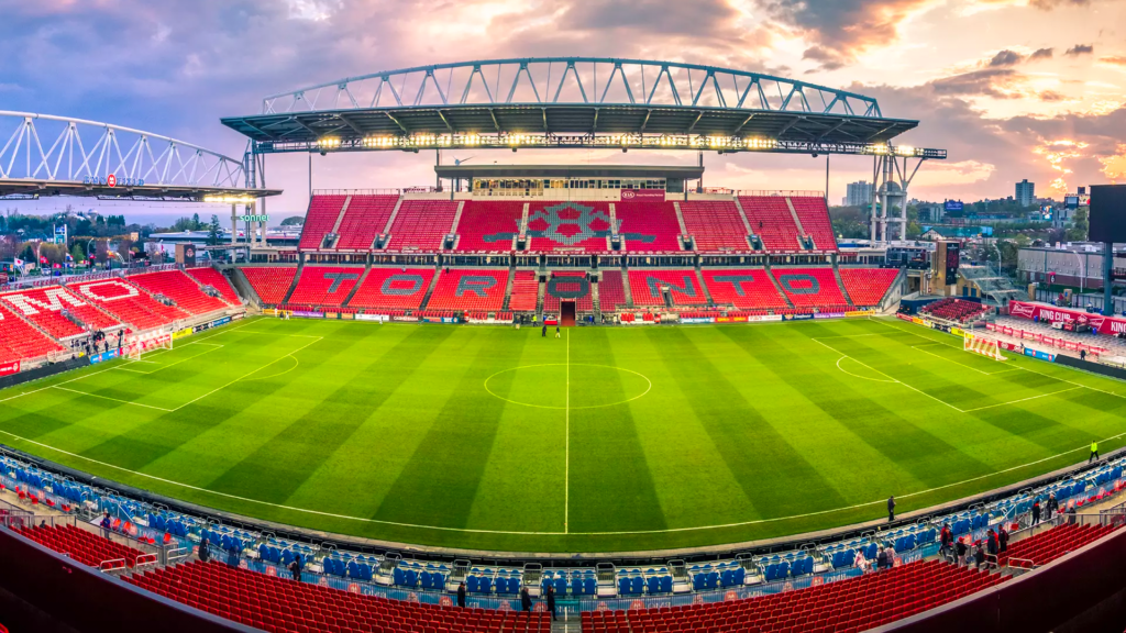 Vista panorâmica do BMO Field em Toronto, com o horizonte da cidade e a CN Tower ao fundo, iluminado sob um céu vibrante, pronto para a Copa do Mundo.