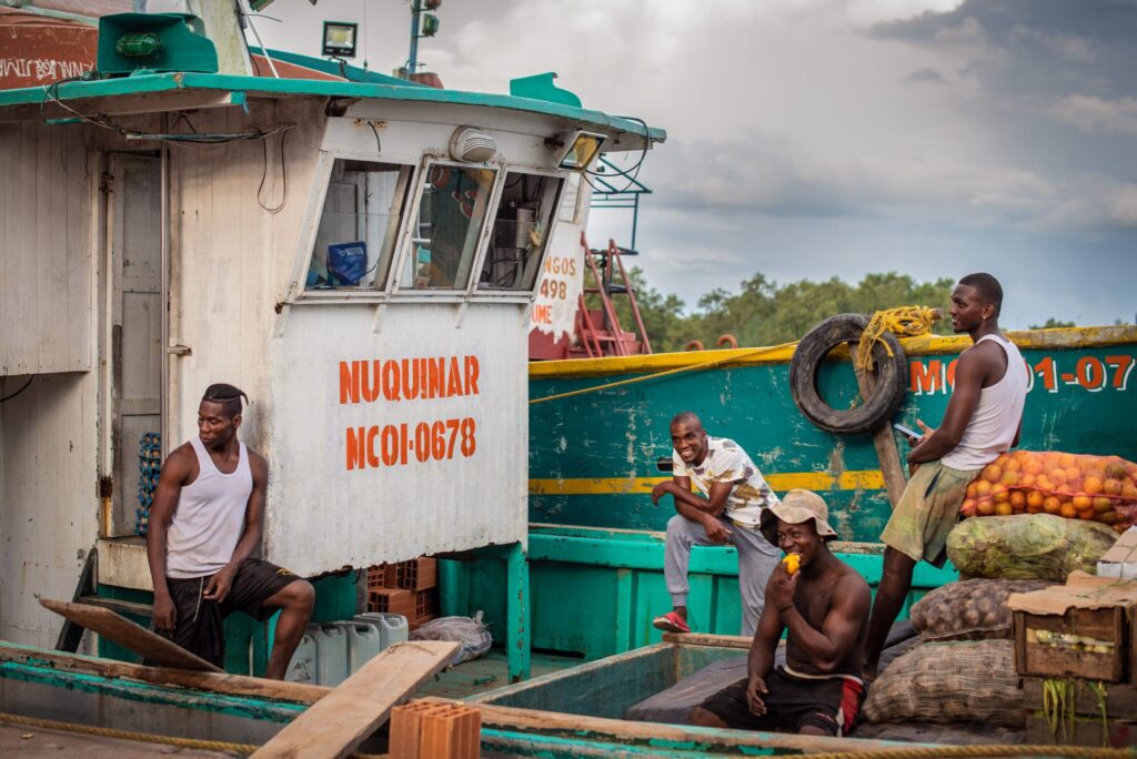 Salário Mínimo no Suriname em Reais: Qual o Valor em 2026? Eu organizando meus documentos de imigração e anotações sobre o visto de trabalho em uma cafeteria charmosa em Paramaribo.