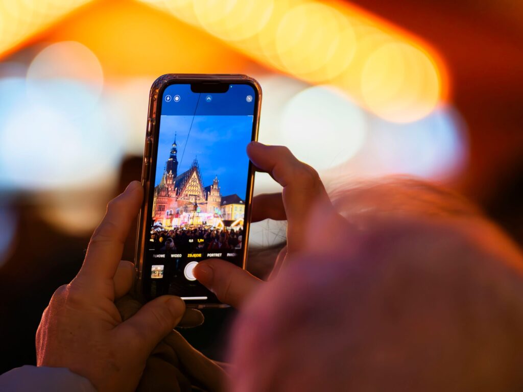 O Erro com Celular que Todo Brasileiro Comete ao Chegar na Europa Eu segurando meu smartphone com expressão de preocupação e conferindo anotações sobre o uso de dados no exterior em um aeroporto na Europa.
