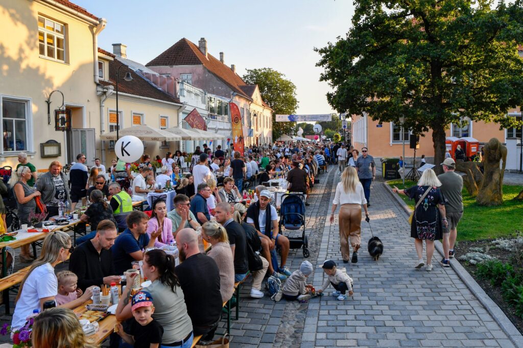 Custo de Vida na Estônia em 2026: Quanto Gasto Morando Aqui? Eu sorrindo enquanto analiso minhas anotações detalhadas sobre orçamento mensal e custo de vida em uma cafeteria aconchegante em Tallinn.