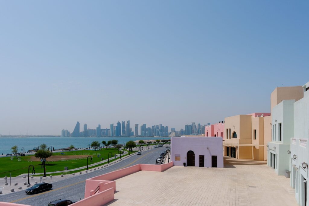 Morar no Catar em 2026: Custo de Vida, Vistos e Como Funciona Eu sorrindo enquanto organizo minhas anotações e planejamento para morar no Catar em uma cafeteria charmosa em Doha.