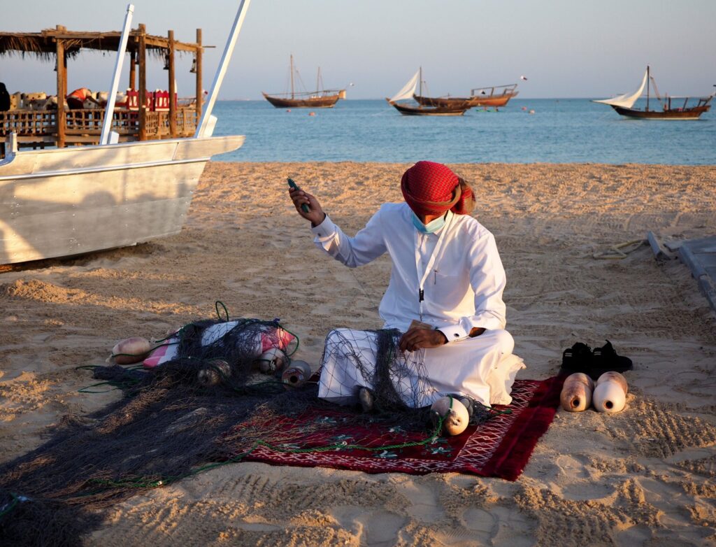 Trabalhar no Catar em 2026: Vistos, Salários e Oportunidades Eu sorrindo enquanto organizo minhas anotações e planejamento de carreira para trabalhar no Catar em uma cafeteria charmosa em Doha.