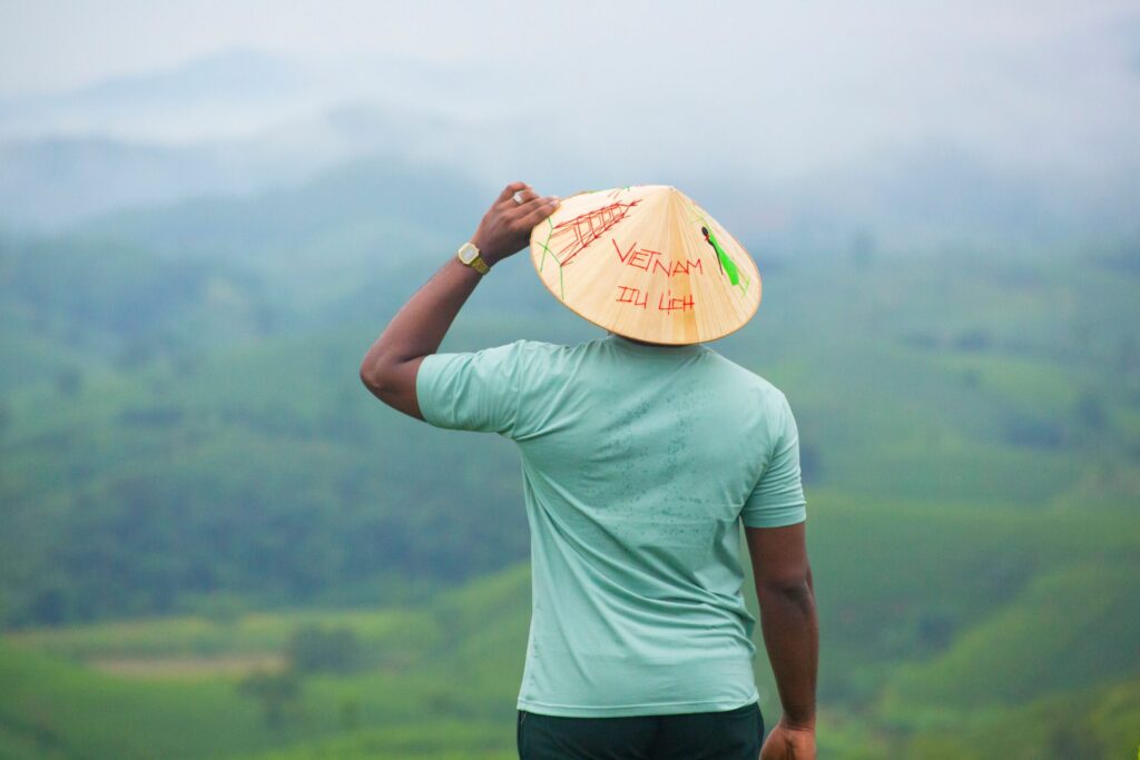 Morar no Vietnã em 2026: Custo de Vida, Vistos e Dicas Úteis Xícara de café vietnamita tradicional ao lado de um livro de idiomas e um smartphone.