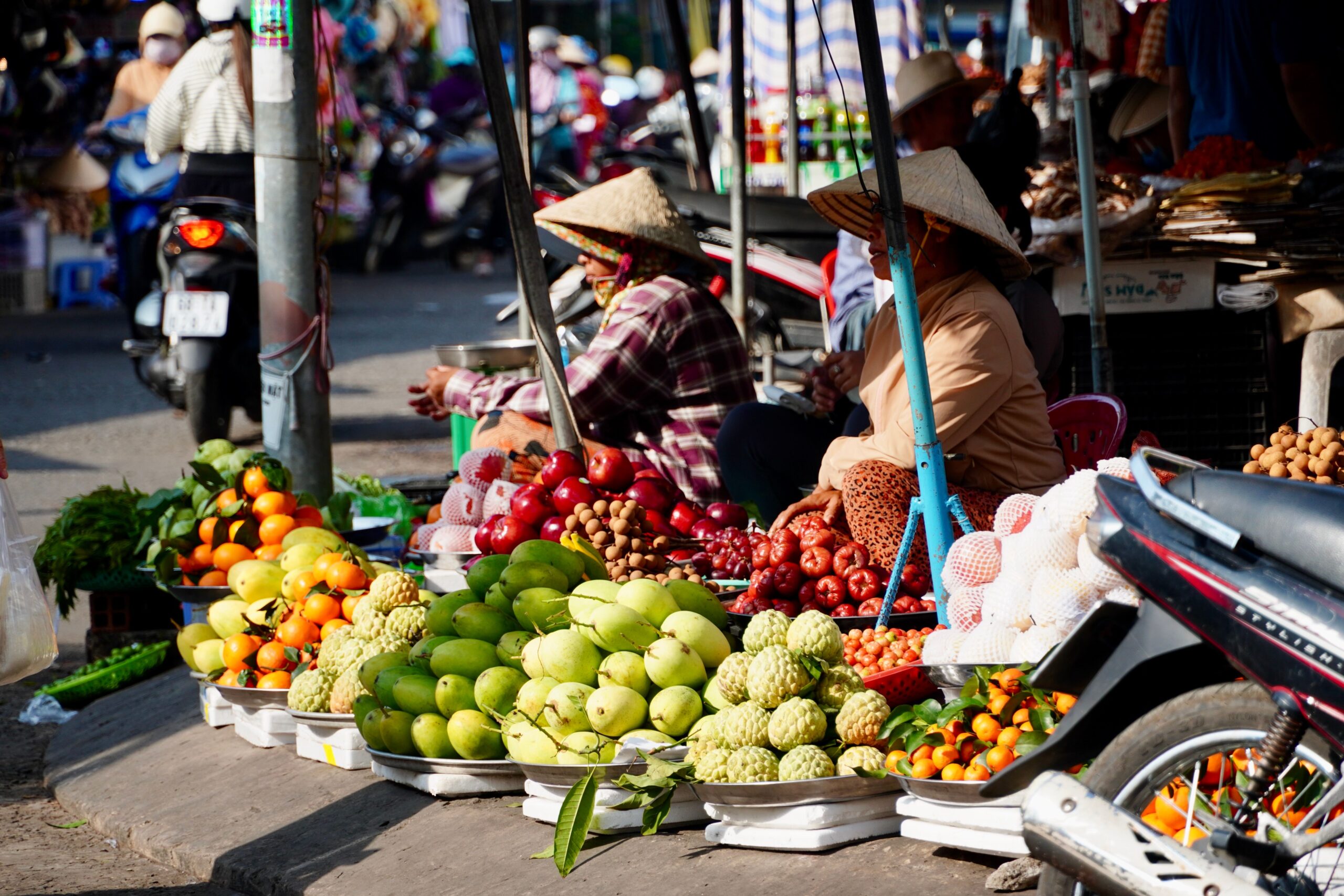 Mercado de rua vietnamita com barracas de comida e frutas