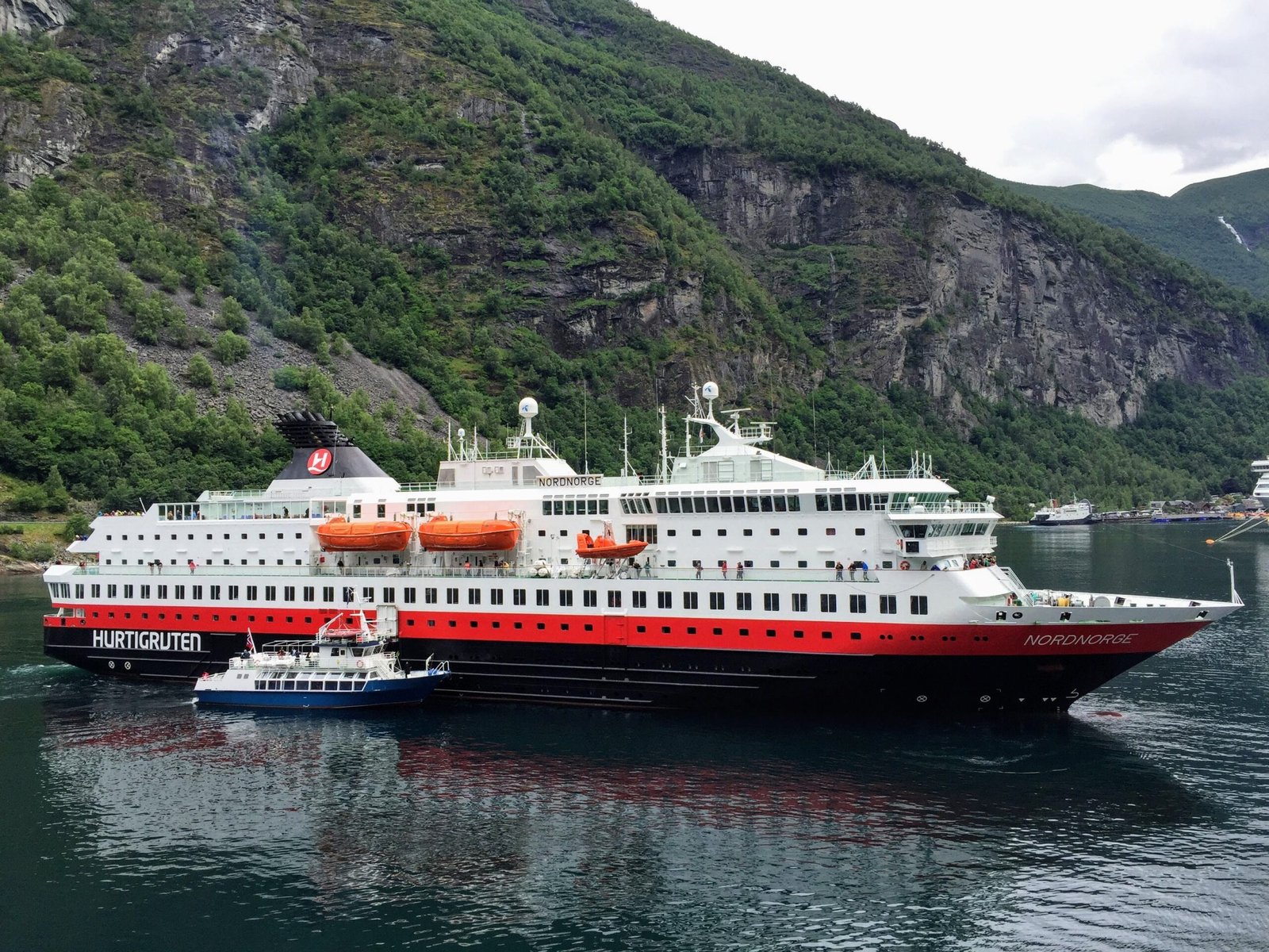 Cruzeiro pelos fiordes noruegueses: a paisagem que justifica a viagem Cruzeiro pelos fiordes noruegueses navegando entre montanhas e cachoeiras em 2026