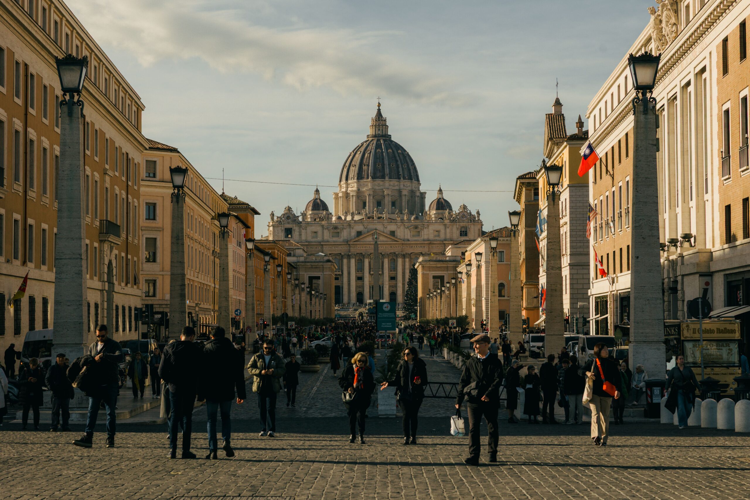 Vista aérea da Cidade do Vaticano e de Roma ao entardecer, mostrando a divisão entre os dois territórios