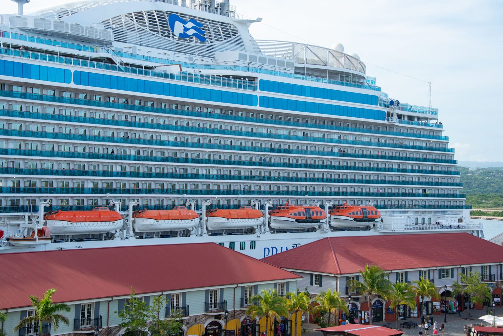 Cruzeiro no Caribe 2026: roteiros, valores e dicas para brasileiros Navio de cruzeiro navegando em mar azul-turquesa em um cruzeiro no Caribe em 2026