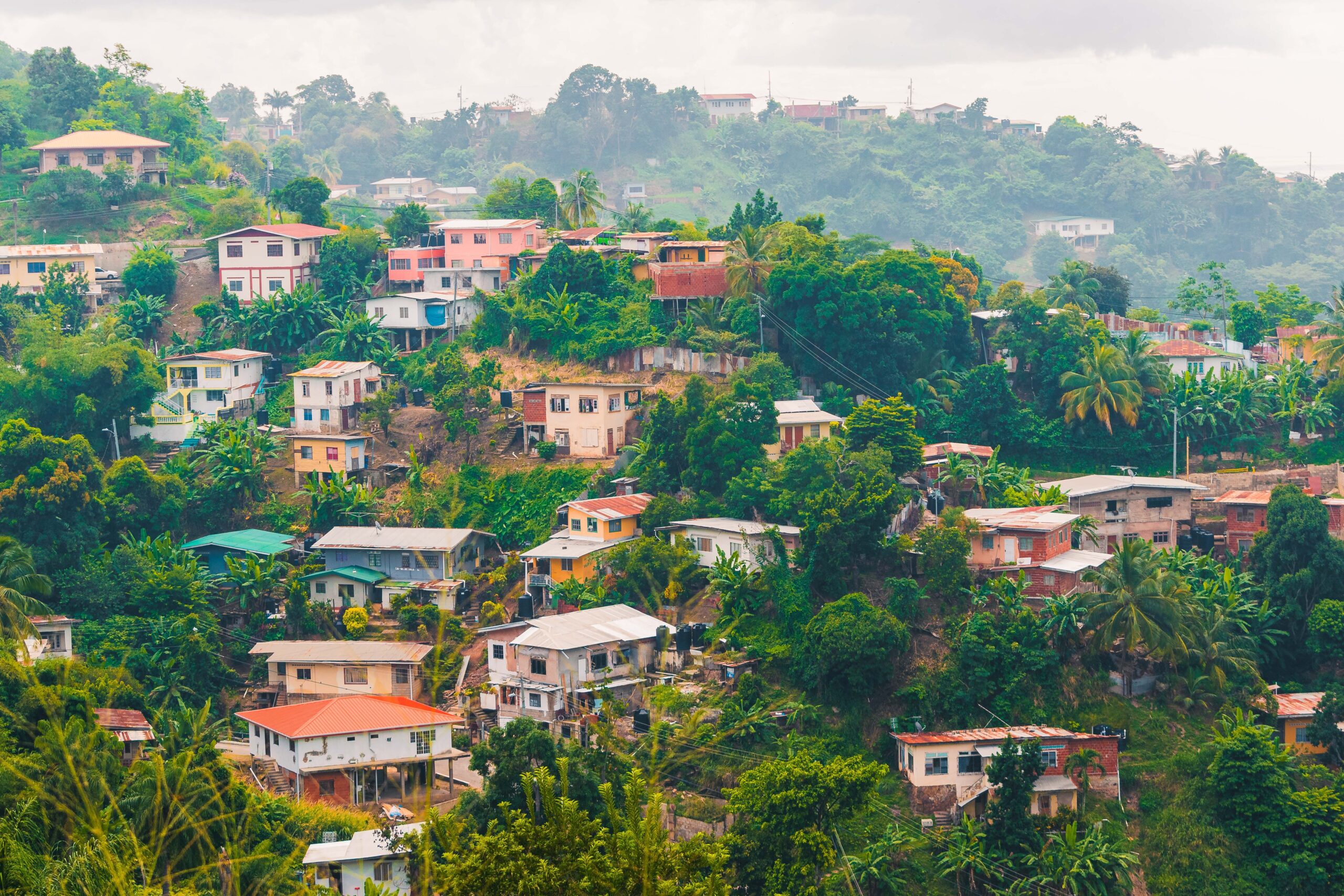 Visto e documentação para morar na Jamaica em 2026 Rua comercial em Kingston, Jamaica, com carros e movimento de pedestres