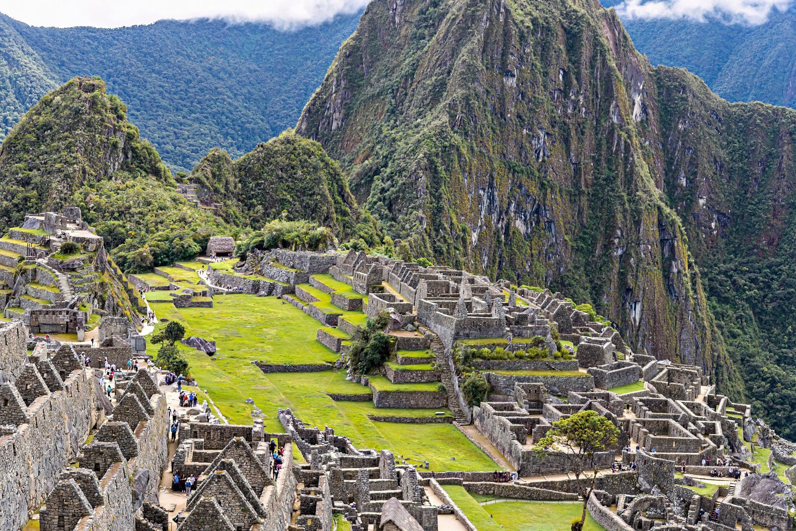 Como economizar em Cusco antes de ir a Machu Picchu Rua de pedra em Cusco com arquitetura colonial e inca ao fundo