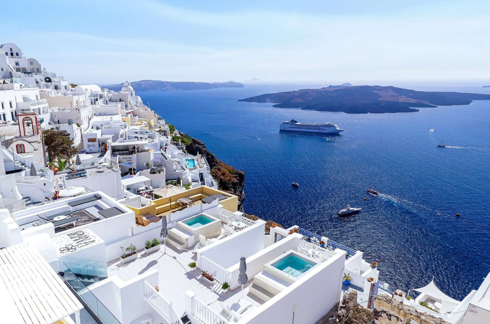 Cruzeiro pelas Ilhas Gregas em 2026 Navio de cruzeiro ancorado próximo às casas brancas de Santorini nas ilhas gregas