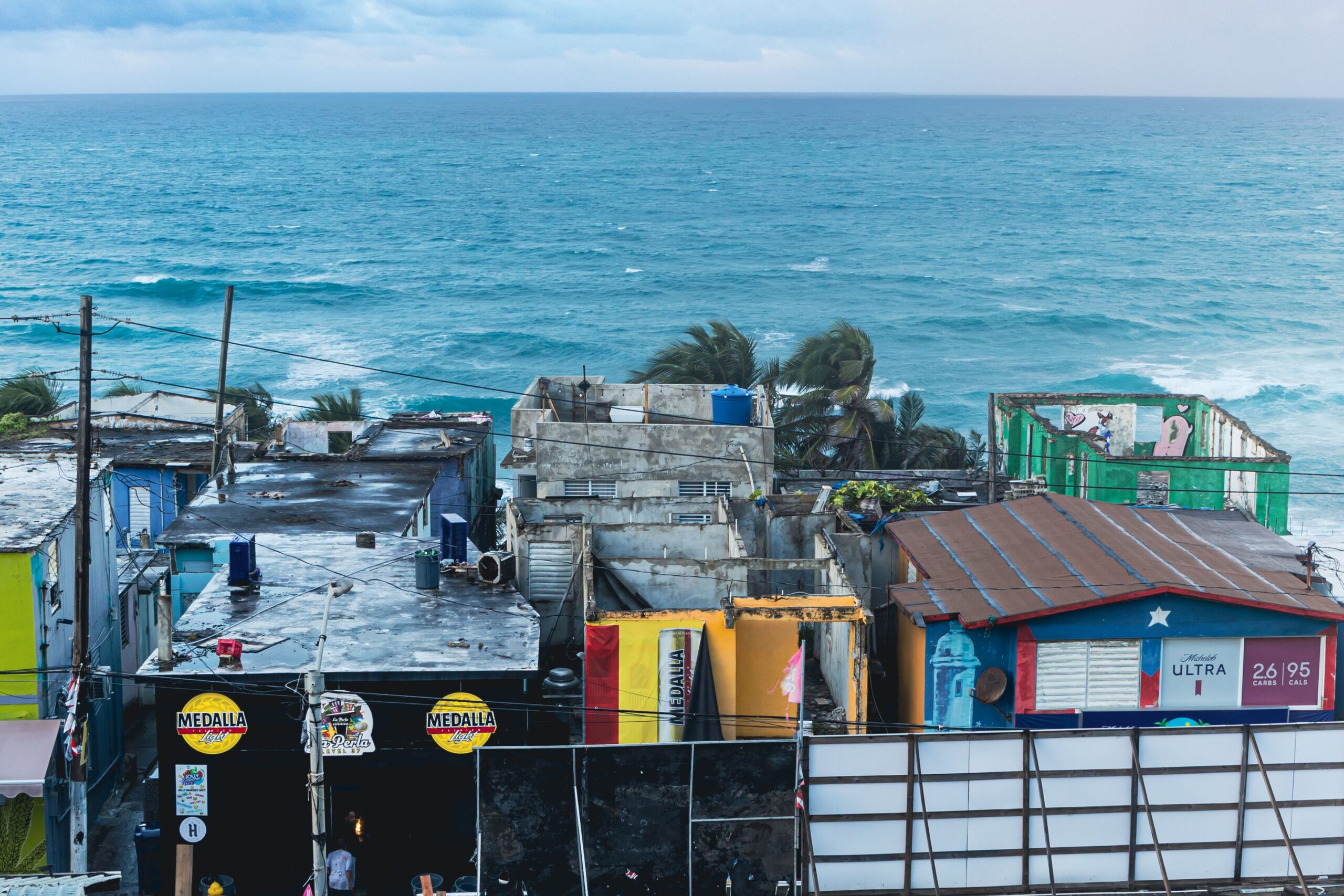 O que ninguém conta sobre morar na Jamaica Rua colorida em vila jamaicana com casas de madeira e vegetação tropical