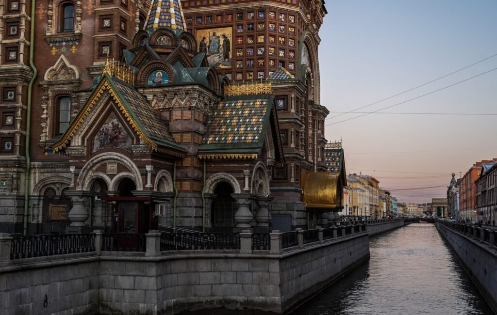 Rússia vs Estônia: Onde Vale Mais a Pena em 2026? Canais de São Petersburgo com arquitetura clássica e reflexos na água ao entardecer.