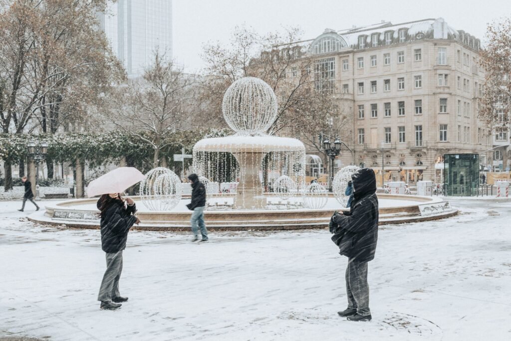 Inverno na Europa 2026/2027: Quando Começa e Melhores Destinos Mercado de Natal tradicional na Alemanha com barracas decoradas, luzes e pessoas aproveitando o clima invernal.