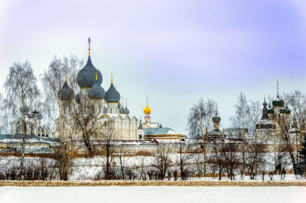 Roteiro de 5, 7 e 10 Dias para a Rússia em 2026 Cúpulas de igreja ortodoxa com detalhes em estilo russo cobertas parcialmente por neve e árvores ao fundo.