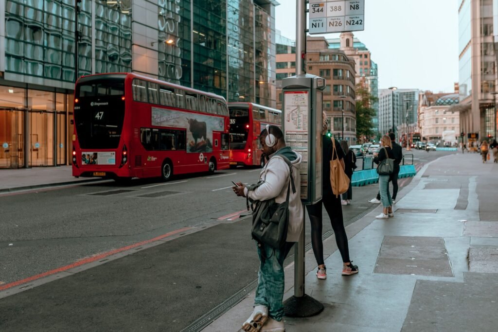 Inglaterra Vale a Pena para Brasileiros em 2026? Guia Família passeando em um parque público arborizado em Londres com transporte público ao fundo.